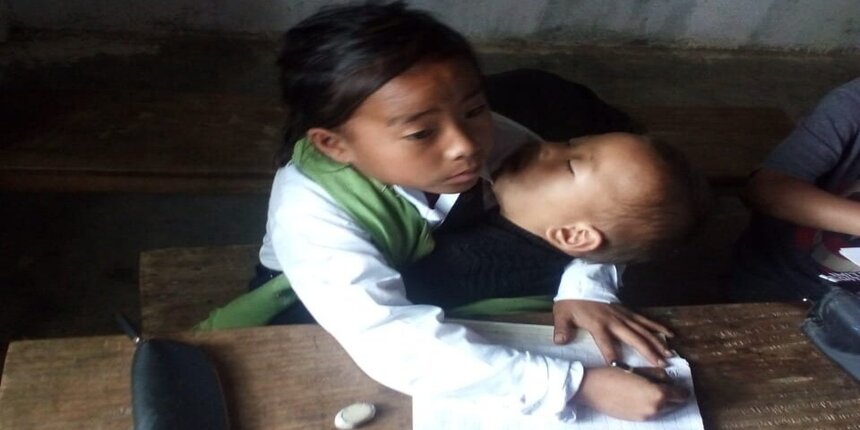 Meiningsinliu Pamei from Tamenglong, Manipur attends school babysitting her sister (image source: Biswajit Singh official Twitter)
