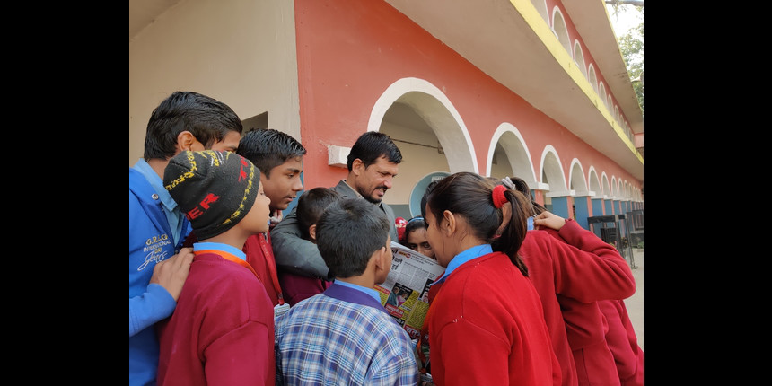Principal Ranjan Kumar reading the newspaper with students
